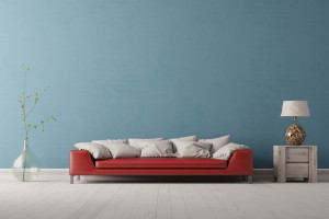 Interior of living room with a red sofa in front of a blue wall (3D Rendering)